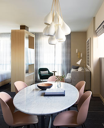 Hotel Wilshire’s Hollywood suite with dining table, living room with TV and bedroom