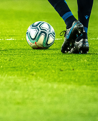 Soccer player on pitch with a soccer ball